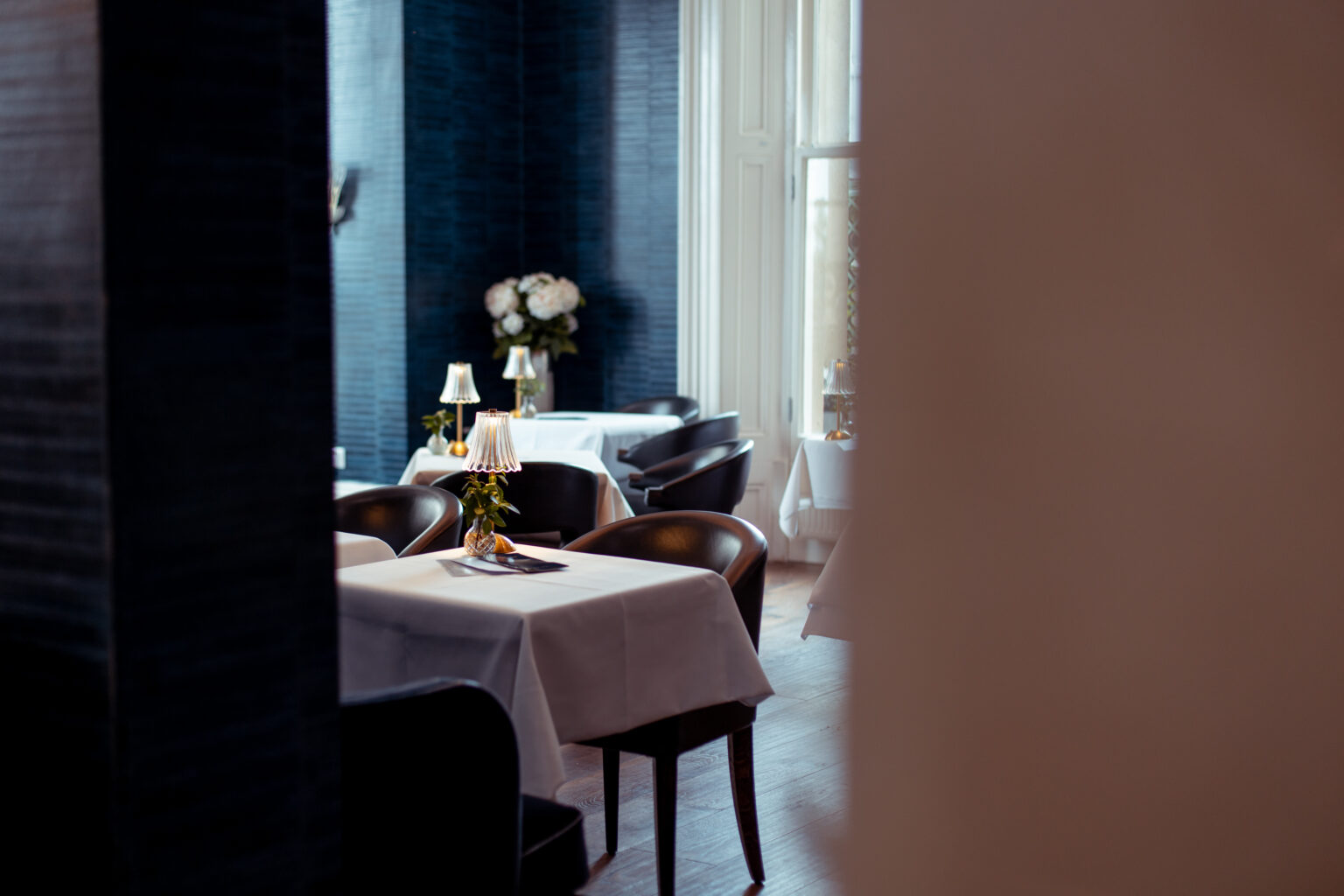 Navy panelled dining room laid for dinner at The Chatsworth Hotel